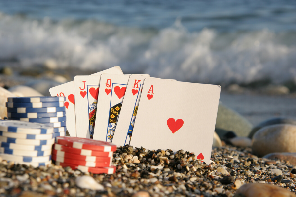 Playing cards and poker chips in the sand.