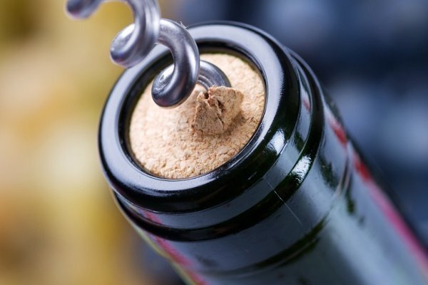 A bottle of wine being uncorked.