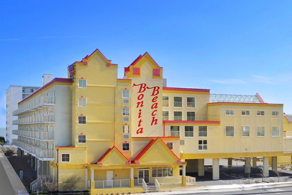 a yellow hotel with a red and white sign on it