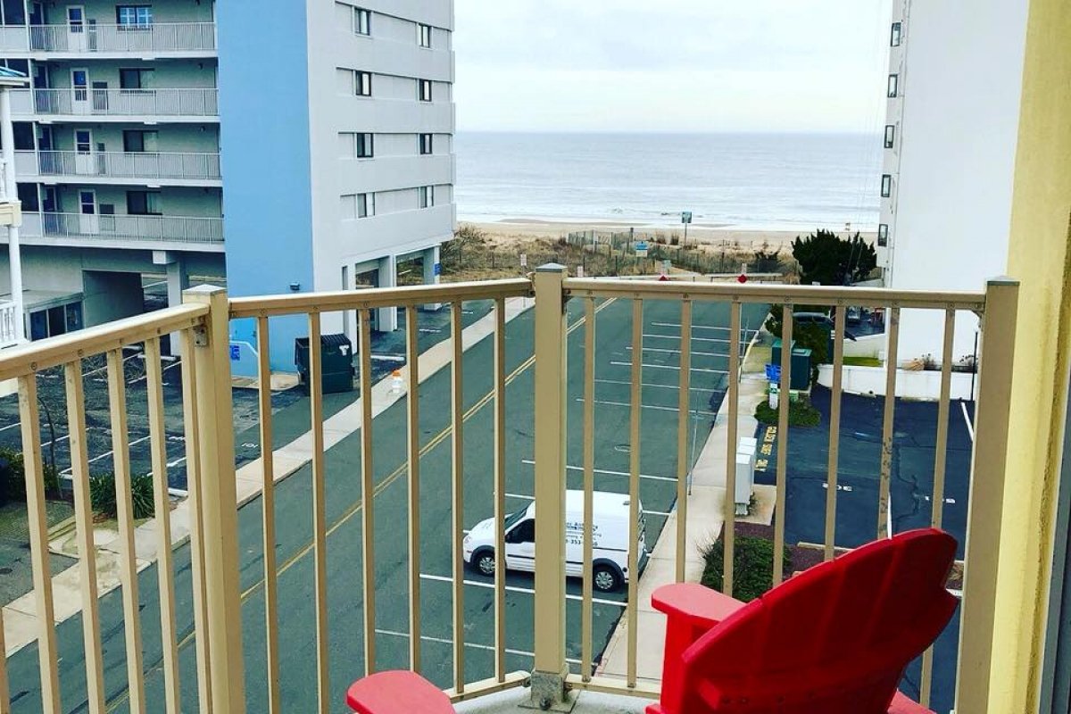 two red chairs sitting on top of a balcony